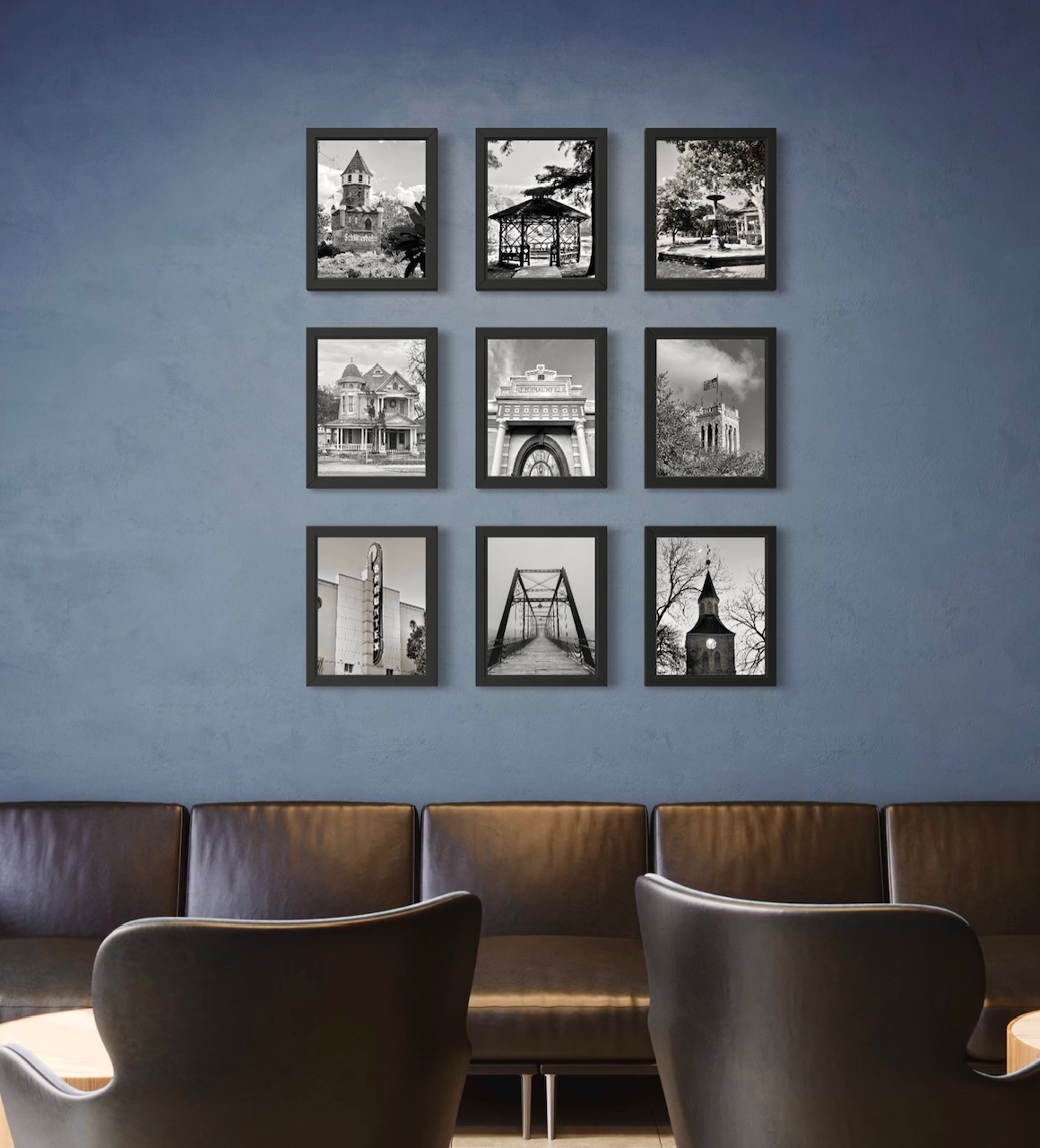 Nine black and white photographs of New Braunfels landmarks in a grid on a blue-grey lounge wall